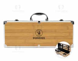 Kit para churrasco composto por cinco peças em inox com cabo em madeira de carvalho: faca com lâmina de 8 polegadas, espátula com cerdas de silicone, garfo de duas pontas, pegador de alimentos e uma espátula multiuso com lâminas serradas laterais e abridor de garrafas embutido. Acompanha maleta com acabamento amadeirado com detalhes em alumínio e trava de segurança para fechamento, além de revestimento interno em tecido Oxford e suportes em velcro para fixação dos itens.