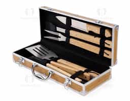Kit para churrasco composto por cinco peças em inox com cabo em madeira de carvalho: faca com lâmina de 8 polegadas, espátula com cerdas de silicone, garfo de duas pontas, pegador de alimentos e uma espátula multiuso com lâminas serradas laterais e abridor de garrafas embutido. Acompanha maleta com acabamento amadeirado com detalhes em alumínio e trava de segurança para fechamento, além de revestimento interno em tecido Oxford e suportes em velcro para fixação dos itens.