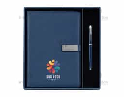 Kit executivo composto por dois itens: um caderno fichário e uma caneta. O caderno tipo fichário possui capa em couro sintético, fecho magnético e plaquinha metálica fixa à aba, mecanismo de argolas em aço carbono com abertura facilitada, aproximadamente 99 folhas de tamanho A5 pautadas em marfim com espaço para assinalar dias da semana e datas numéricas e interior da capa com compartimento para cartões e porta-canetas. A caneta metálica possui detalhes em plástico e carga esferográfica preta de 0,8 mm. Acompanha caixa em papelão com berço em PET com revestimento aveludado para acomodação dos itens.