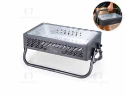 Churrasqueira em ferro com aberturas para ventilação e pés montáveis, que também podem ser utilizados como alças para transporte quando a churrasqueira não estiver em uso. Conta ainda com grelha em metal galvanizado e bandeja metálica com alças removíveis para acomodação do carvão.